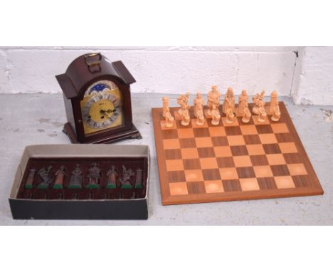 A reproduction mantel clock with moon face dial, height 27cm and a Tudor Kings and Queens 1485-1603 resin chess set and board