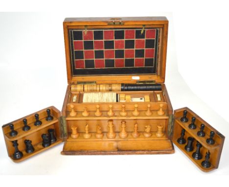 A Victorian mahogany games compendium, the upper lift out tray set with bone dominoes and draught pieces and with chess set t
