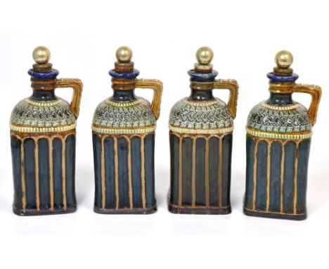 A set of four Doulton Lambeth stoneware decanters, each with a silver plated cork stopper, various initials to the handles, h