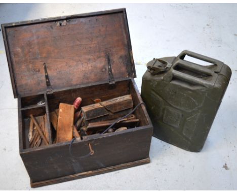 A wooden toolbox containing a quantity of tools to include moulding planes and a jerry can.