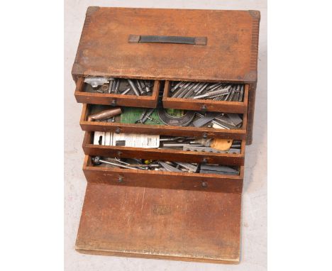 A small wooden toolbox with seven integral drawers containing a quantity of workman's tools.