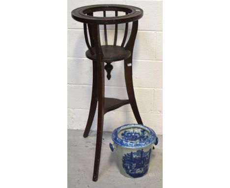 A mahogany jardinière stand with lower tier on outstretched supports, containing a blue and white ceramic jardinière, height 