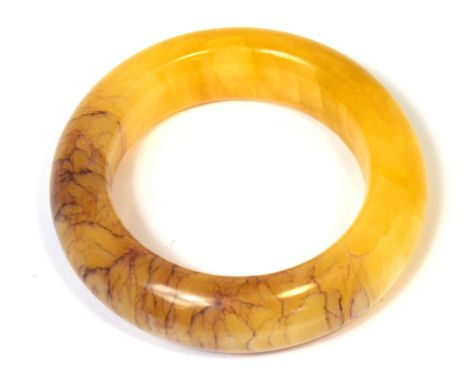 A Tibetan yellow and red jade bangle, diameter 10cm.