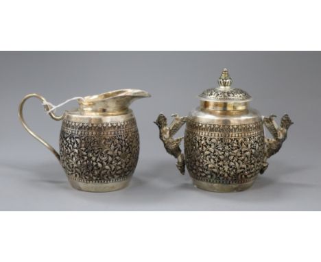 Two items of Burmese 900 silver by Paung, comprising a sucrier and cover of barrel form with ornate embossed floral and folia