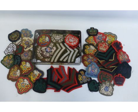 A tin of British Army cloth rank badges.