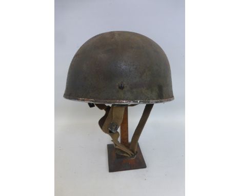 A 1955 British Paratrooper's helmet with liner and chin strap.