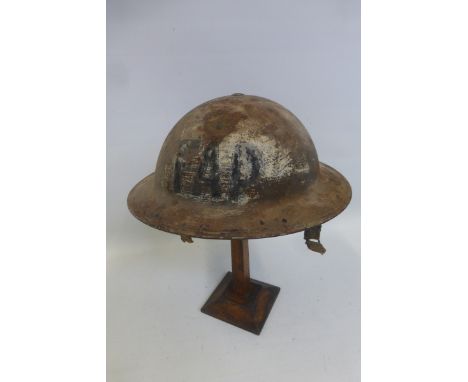 A WW2 British F.A.P. First Aid Post helmet with liner and damaged chin strap.