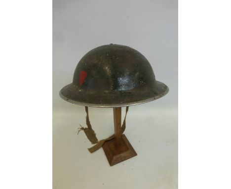 A WW2 British Army helmet dated 1939 with painted divisional markings, complete with liner and damaged chin strap.