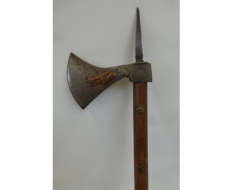 Possibly an Indian war axe, having copper figures overlaid on the steel head and mounted on a wooden shaft with brass decorat