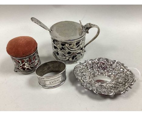 A Victorian Hallmarked Silver Pin Cushion, the pierced surround with cherub detail in relief, on three scroll feet, a hallmar