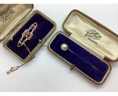 An Edwardian Amethyst and Seed Pearl Brooch, of sinuous openwork design with foliage decoration to centre and safety chain, s