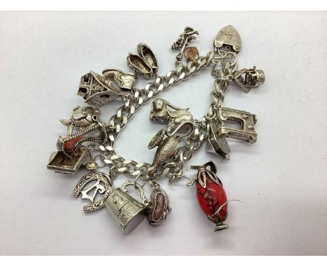 A Vintage Chunky Curb Link Charm Bracelet, suspending assorted novelty charms, including articulated genie's lamp, souvenir s
