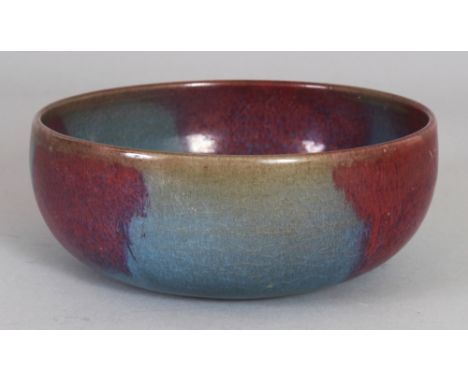 A CHINESE JUN WARE PURPLE SPLASH CERAMIC BOWL, with rounded sides, the base with five spur marks, 6.25in wide at widest point
