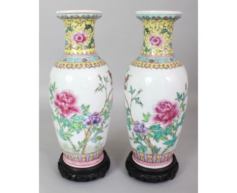 A PAIR OF 20TH CENTURY CHINESE FAMILLE ROSE PORCELAIN VASES, together with a fitted wood stands, each base with a Jingezhen s