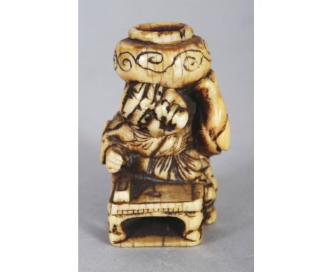 A GOOD JAPANESE EDO/MEIJI PERIOD IVORY NETSUKE OF SHOKI, crouching before a low table and supporting a cauldron on his should