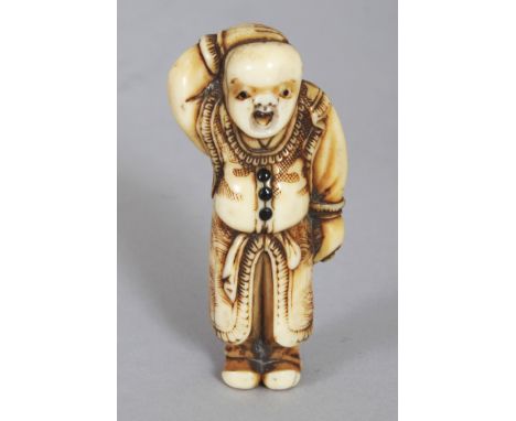 A GOOD QUALITY JAPANESE EDO/MEIJI PERIOD IVORY NETSUKE OF A STANDING BOY, the buttons of his costume inlaid in ebony, 2.25in 