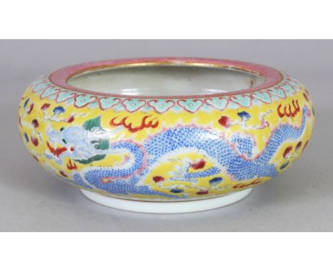 A CHINESE YELLOW GROUND FAMILLE ROSE PORCELAIN DRAGON BRUSHWASHER, the base with a Qianlong seal mark, 5.8in wide at widest p