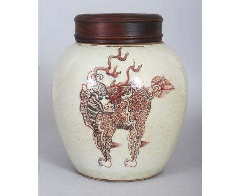 A CHINESE COPPER RED PORCELAIN KYLIN JAR, together with a fitted pierced wood cover, the base with a six-character Kangxi mar