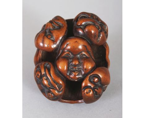 A GOOD QUALITY JAPANESE MEIJI PERIOD WOOD NOH MASK NETSUKE, carved and pierced with nine interconnecting Noh masks, 1.5in wid
