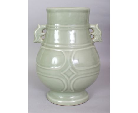 A CHINESE CELADON PORCELAIN RIBBED HU VASE, the base with a Qianlong seal mark, 8.2in wide including handles & 11.1in high.