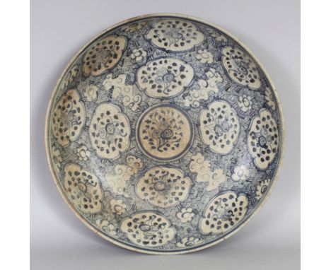 A CHINESE LATE MING DYNASTY SWATOW BLUE & WHITE CERAMIC SAUCER DISH, painted with repeated quatrefoil floral spray panels, 12