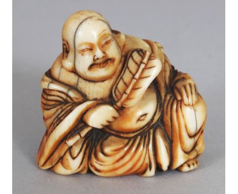 A GOOD QUALITY JAPANESE EDO/MEIJI PERIOD IVORY NETSUKE OF HOTEI, seated in a reclining posture and holding a fan, 1.25in wide