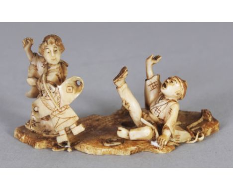 AN UNUSUAL SIGNED JAPANESE MEIJI PERIOD IVORY NETSUKE OF A LADY BEARING A KITE, her son in an animated posture on the ground 