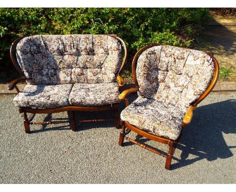 Two seater stick-back sofa and a stick-back arm chair with loose cushion backs and seats - (see also lot 172)