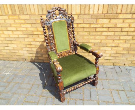 A Victorian oak carver chair, the crest rail carved with foliate decoration, padded back in a surround of vines and barley-tw