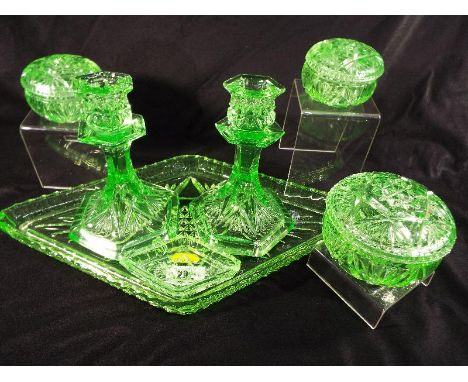 A collection of Uranium glass to include a dressing table tray, candlesticks, lidded trinket dishes and other (qty)