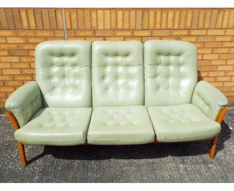 Ercol - a Golden Dawn three seater sofa with pale green leather cushioned back, seats and arms