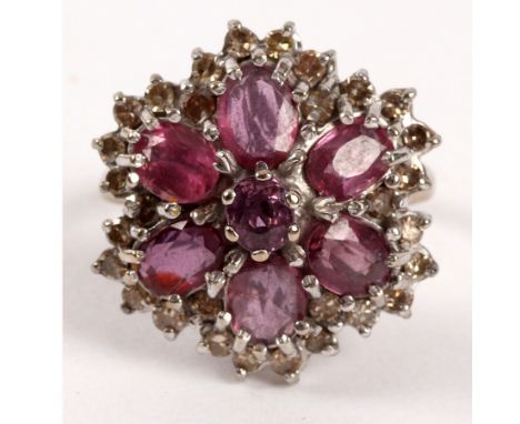 A ruby and diamond cluster ring, the central seven-stone flowerhead cluster to a diamond border set in 18ct white gold, size 