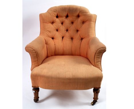 A Victorian button back armchair on moulded front legs