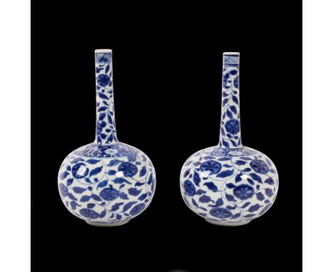 A pair of Chinese blue and white floral bottle vases, Kangxi, of globe and shaft form, painted scrolling foliage, underglaze 