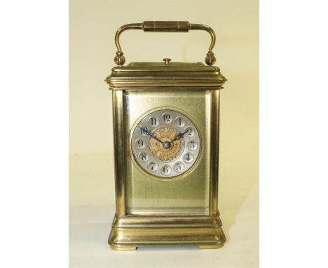 A gilt brass carriage clock, the circular chapter ring with Arabic numerals, fitted an eight-day hour repeat movement, striki