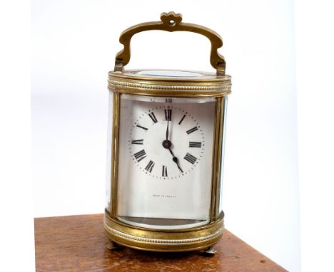 A French gilt brass cased carriage clock, the white enamel dial with Roman numerals in a cylindrical case with glazed panel s