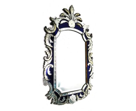 A Venetian wall mirror, the shaped plate with a bevelled edge, the frame with blue mirrored inset and decorated with typical 