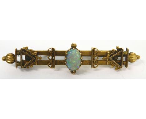 An early 20thC bar brooch, claw set with central opal, of fancy design with plain pin back, marked 15, 5cm long, 3.8g all in.