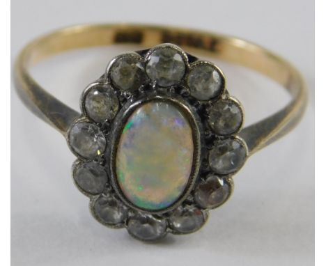 A 9ct gold and silver opal dress ring, the oval stone surrounded by small white stones, size N, 2g all in. 