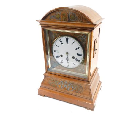 A 19thC walnut cased cuckoo clock, the 18cm diameter Roman numeric dial, in an arched case with a silvered floral inlay, scro