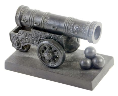 A miniature Russian cast iron model of a 16thC Tsar cannon, the cannon profusely decorated with four cannon balls, on a squar