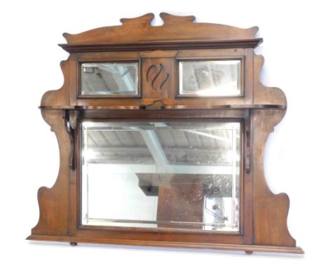 A late 19th/early 20thC walnut overmantel mirror, with a shaped cornice above two bevel mirror plates and a shelf, the larger