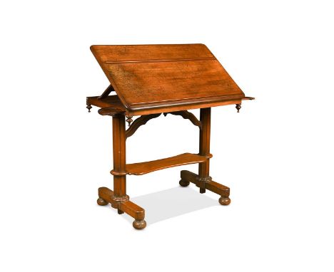 An early Victorian mahogany library table, in the Gothic style, the adjustable hinged top with two moulded book rests, two pu