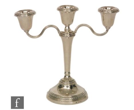 A hallmarked silver three light candelabra, circular stepped base, twin scroll arms and circular sconces, height 22cm, Birmin