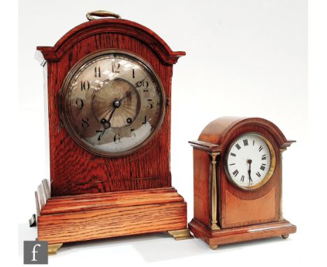 An Edwardian oak cased mantle clock with eight day striking movement stamped and numbered, with silvered radiating fan design