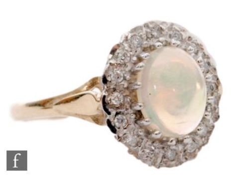 A 9ct hallmarked opal and diamond cluster ring, central oval opal within a a diamond surround and raised shoulders, length 18