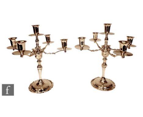 A pair of Mexican Sterling silver five light candelabra, circular scalloped edged bases below knopped columns four scroll arm