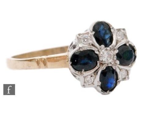 A 9ct hallmarked sapphire and diamond cluster ring shaped circular head with four oval sapphires spaced by diamonds, diameter
