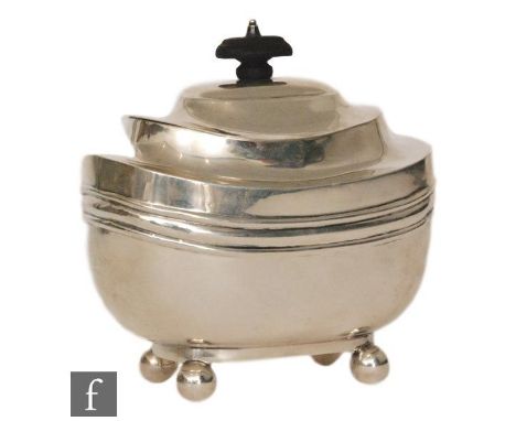 A hallmarked silver boat shaped tea caddy of plain form raised on four ball feet below hinged cover with stepped wooden finia