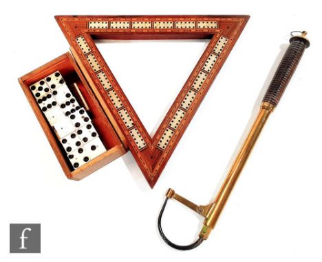 An early 20th Century triangular mahogany cribbage board with four Mr Punch brass pegs, a set of bone dominoes and a brass an